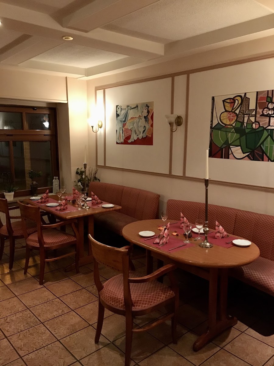 Gemütlicher Innenraum des Ristorante Picasso mit kunstvollen Wandbildern